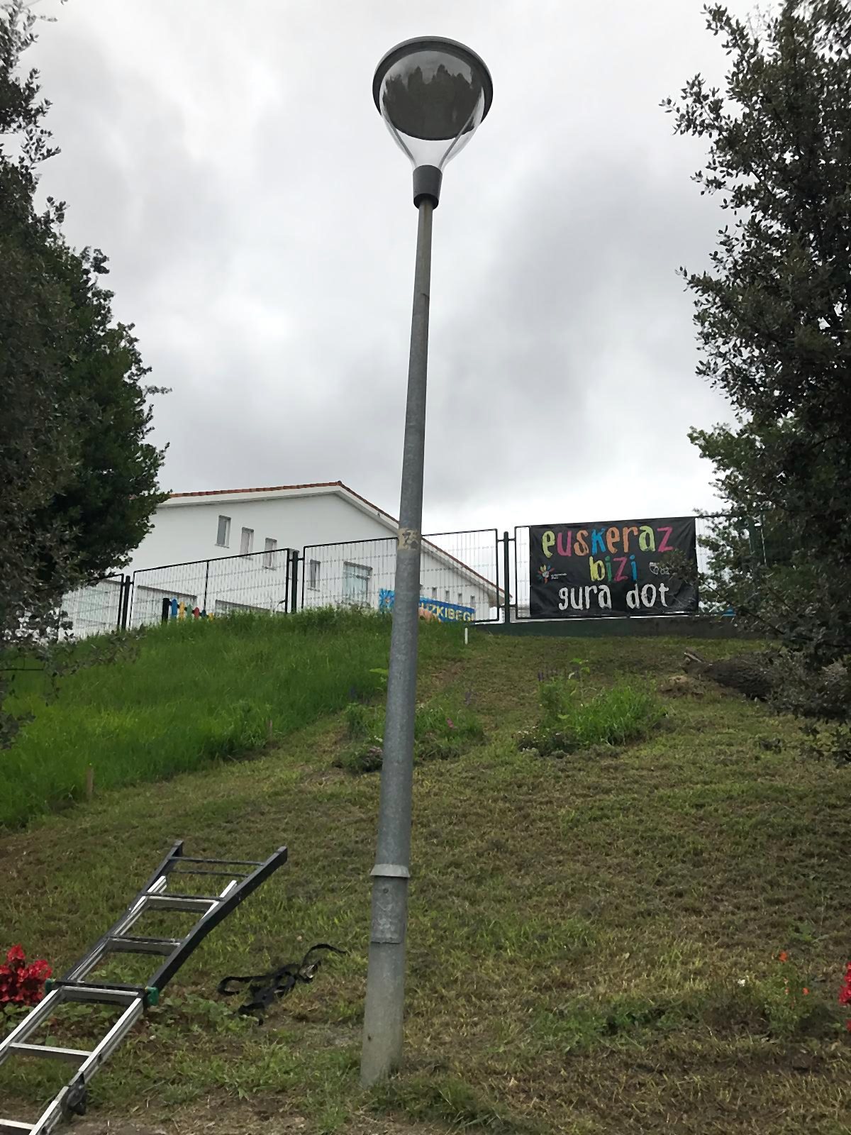 One of the new street lights by the school, with the installation ladder on the grass and the Eguzkibegi sign behind